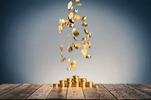 Gold coins falling onto a stack