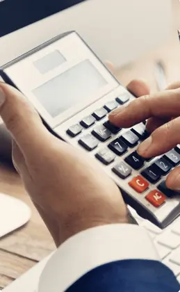 Hands typing on a calculator